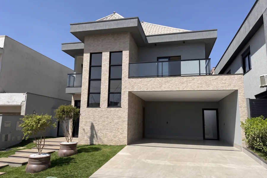 Fachada do Lar MH&D, com revestimento em pedra e garagem coberta