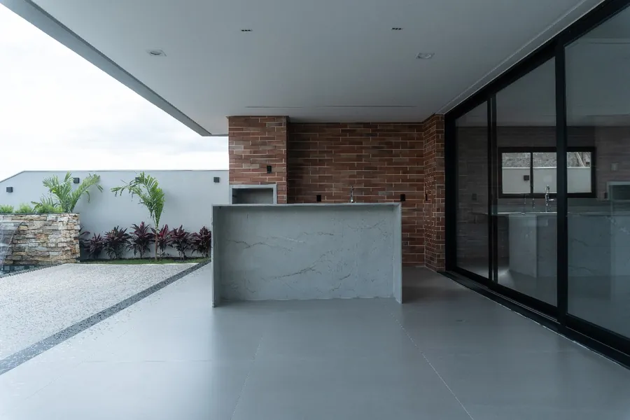 Área gourmet da Casa do Vale, com bancada em pedra e churrasqueira